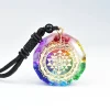 Chakra orgonite pendant with braided cord against a white background