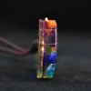 Side view of a chakra orgonite pendant showing layered resin with embedded gemstones