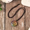 Chakra orgonite necklace laid flat on a rustic wooden surface