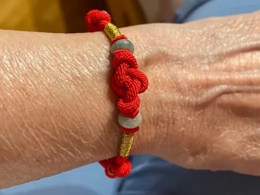 Customer wearing a red string knot bracelet