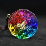 Back of a chakra orgonite pendant showing colorful gemstone chips and gold foil