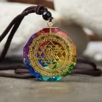 Chakra orgonite pendant with Sri Yantra resting on stone
