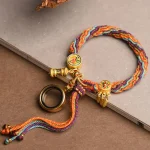 Colorful Tibetan braided bracelet laid flat on grey paper