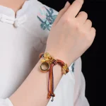 Colorful Tibetan braided bracelet worn on a wrist with a white top