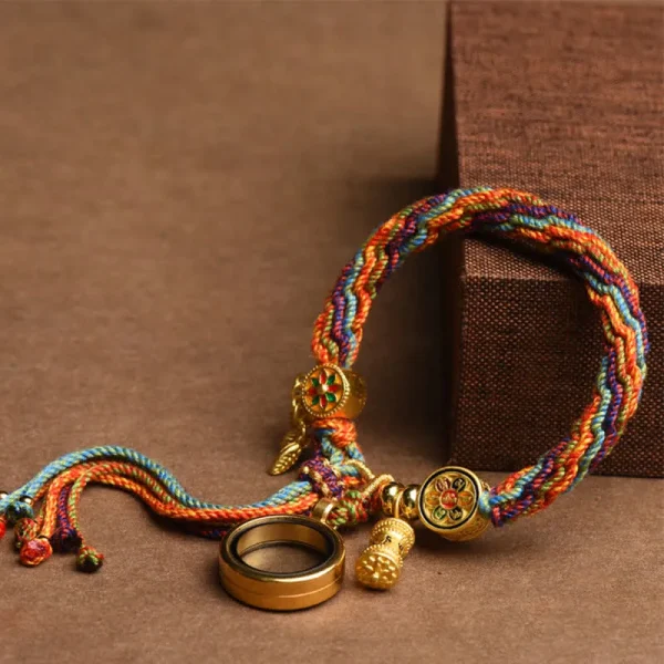 Colorful Tibetan braided bracelet with a prayer wheel charm and magnifying glass charm