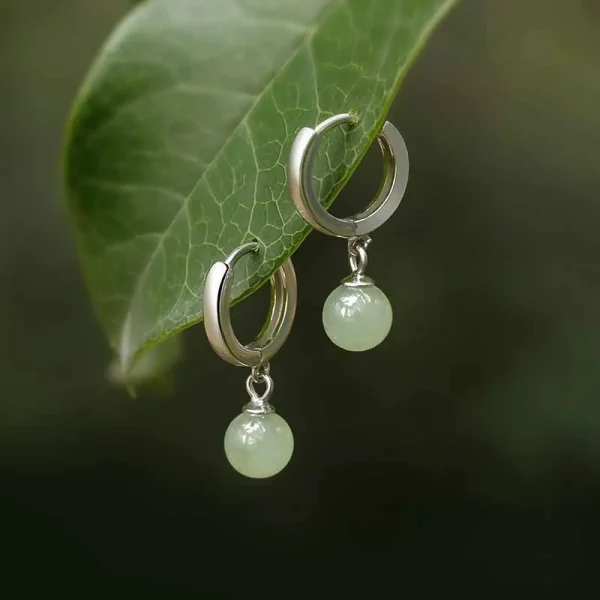 Silver huggie hoop earrings with green jade bead drops