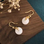 Gold double happiness earrings with white jade coin discs