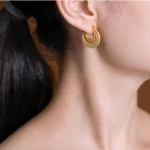 Gold crescent hoop earrings worn in profile
