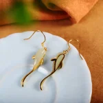 Close up of koi fish jade earrings on a plate