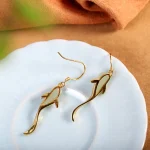 Koi fish earrings with green jade on a plate