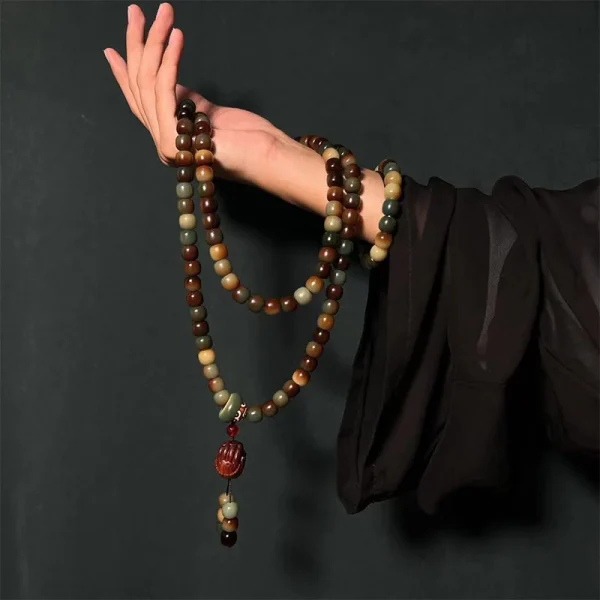 108 multicolor bodhi seed mala beads with a lotus charm held by a hand