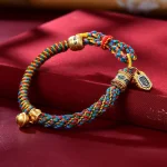 Multicolored Tibetan braided bracelet with prayer wheel and small ghau charm