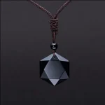 Black obsidian pendant on a knotted cord against a dark background