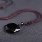 Obsidian pendant necklace laid flat on a dark surface