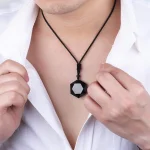 Man wearing a black obsidian pendant necklace over a white shirt