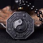 Close up of a black obsidian yin yang bagua pendant