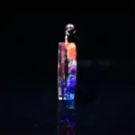 Side view of a thin chakra orgonite pendant showing its thickness